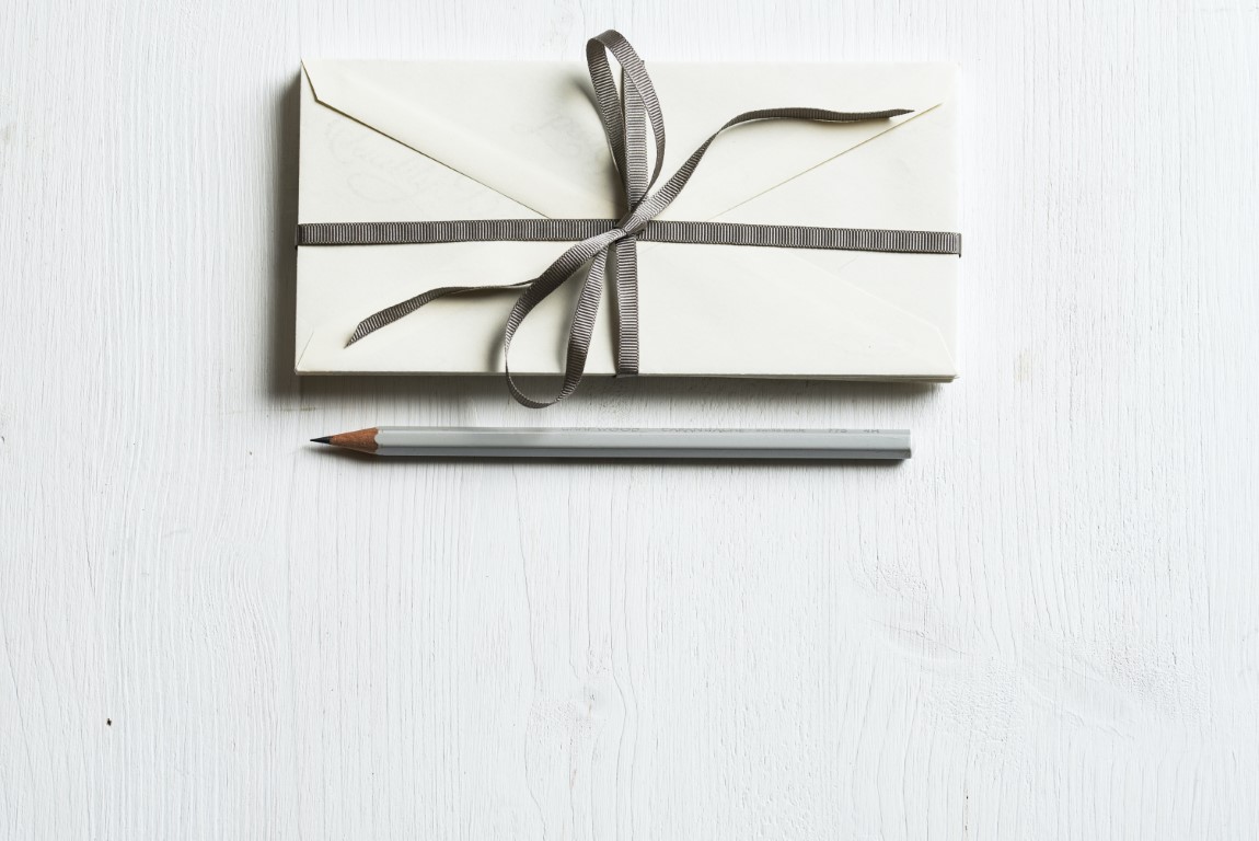 envelope with a ribbon and pencil